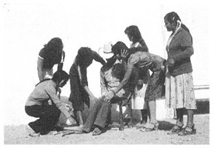 The health workers examine him, find he is disabled by polio and think he may need braces.