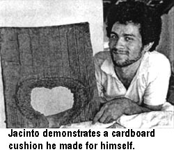 Jacinto demonstrates a cardboard cushion he made for himself.