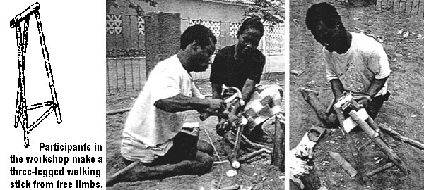 Participants in the workshop make a three-legged walking stick from tree limbs.