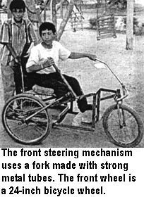 The front steering mechanism uses a fork made with strong metal tubes. The front wheel is a 24-inch bicycle wheel.