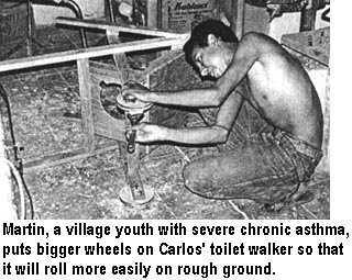 Martín, a village youth with severe chronic asthma, puts bigger wheels on Carlos' toilet walker so that it will roll more easily on rough ground.