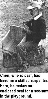 Chon, who is deaf, has become a skilled carpenter. Here, he makes an enclosed seat for a see-saw in the playground.