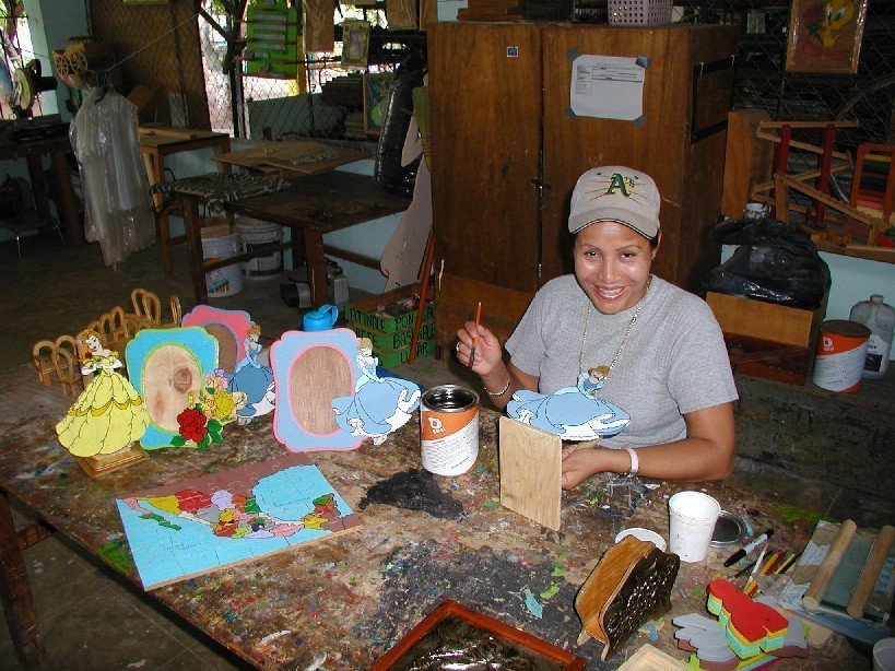 Marielos at work in her woodworking shop.